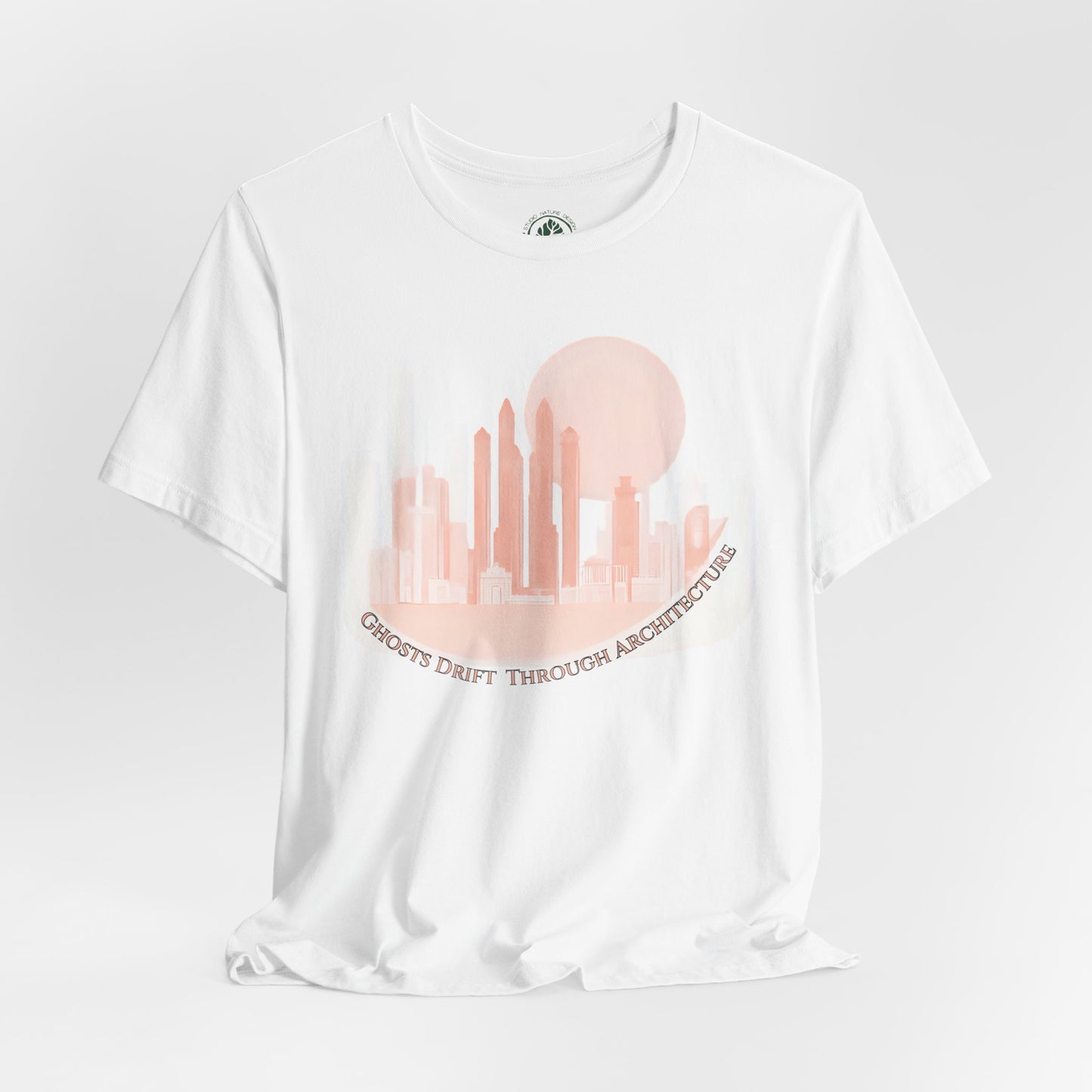 Unisex white t-shirt featuring a coral city skyline with the text “Ghosts Drift Through Architecture” beneath, symbolizing poetic urban design.