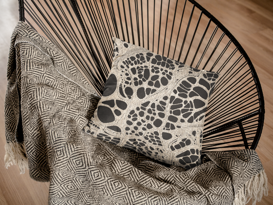 Woven pillow with abstract monochrome pattern resembling urban veins and cellular structures